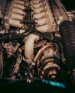 High-resolution image showcasing a complex car engine with intricate wiring and components. Image haute résolution montrant un moteur de voiture complexe avec un câblage et des composants complexes.
