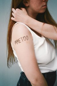 Portrait d'une femme avec #MeToo sur son bras, symbolisant l'autonomisation et la sensibilisation.