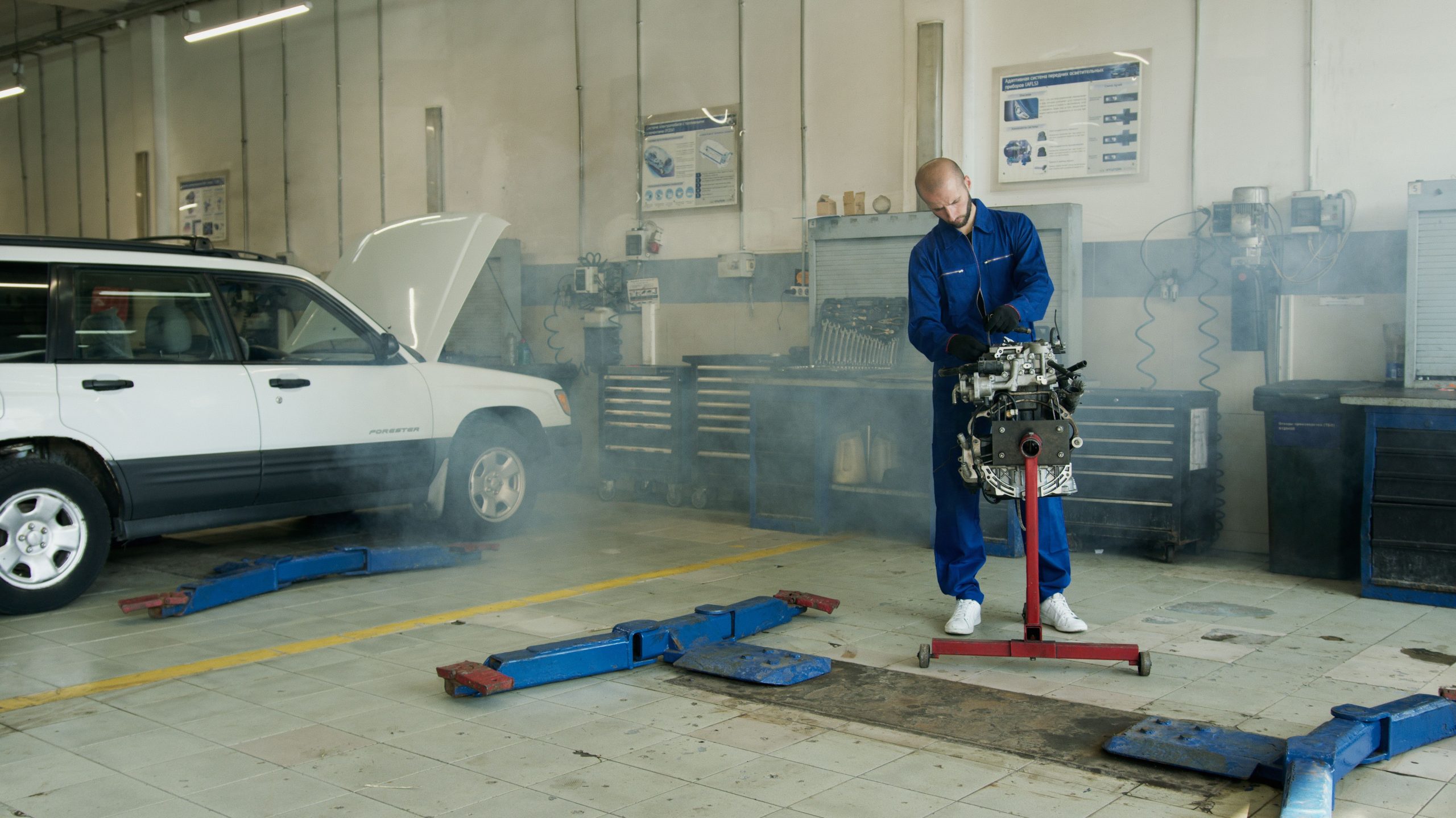 Mécanicien en bleu travaillant sur un moteur automobile
