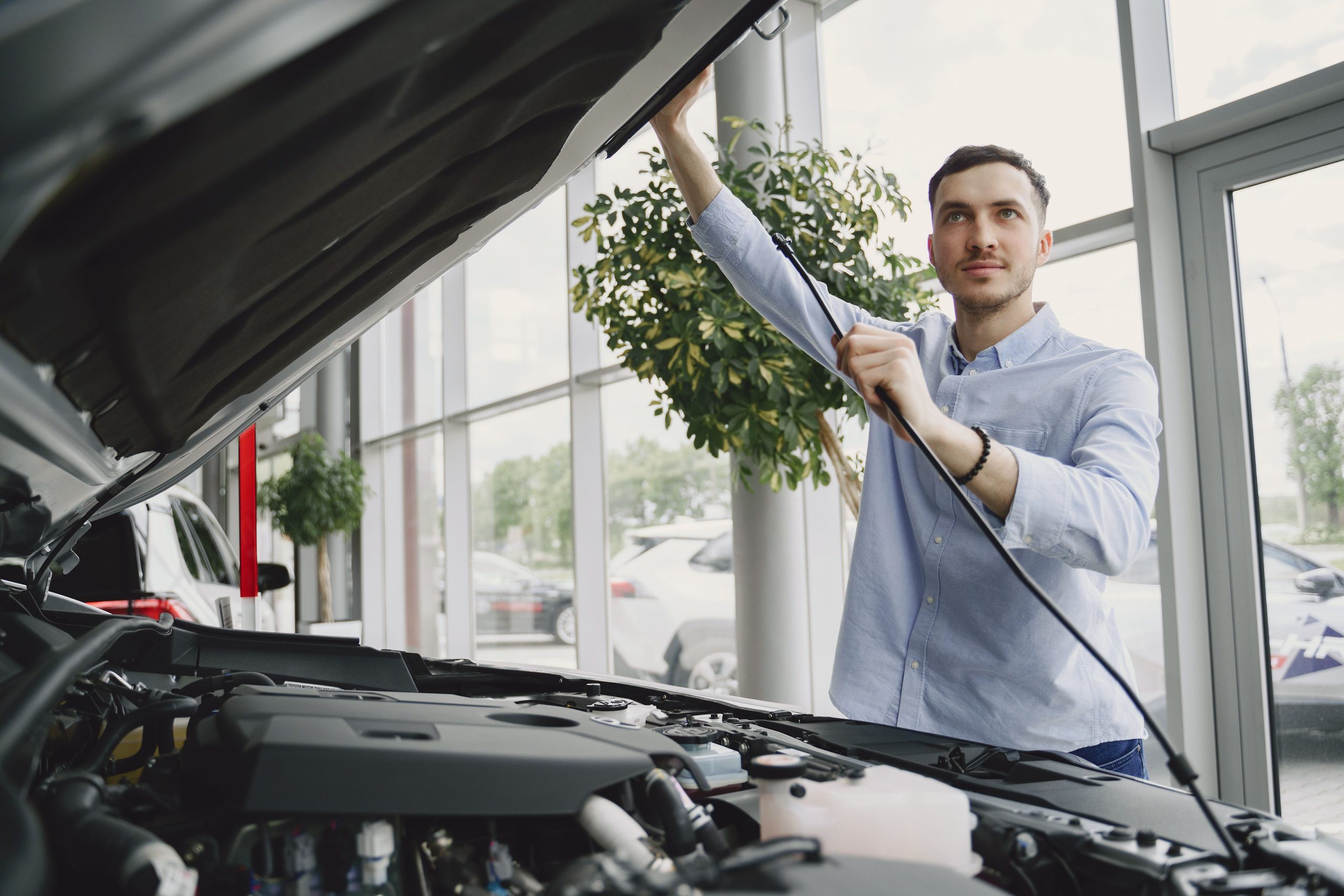 Homme inspectant un moteur dans une concession moderne