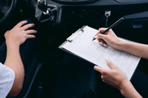 Personne écrivant sur un document dans une voiture