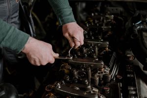 Close-up of a mechanic using hand tools to fix an engine, showcasing precision and skill. Gros plan d'un mécanicien utilisant des outils à main pour réparer un moteur, mettant en avant la précision et le savoir-faire.