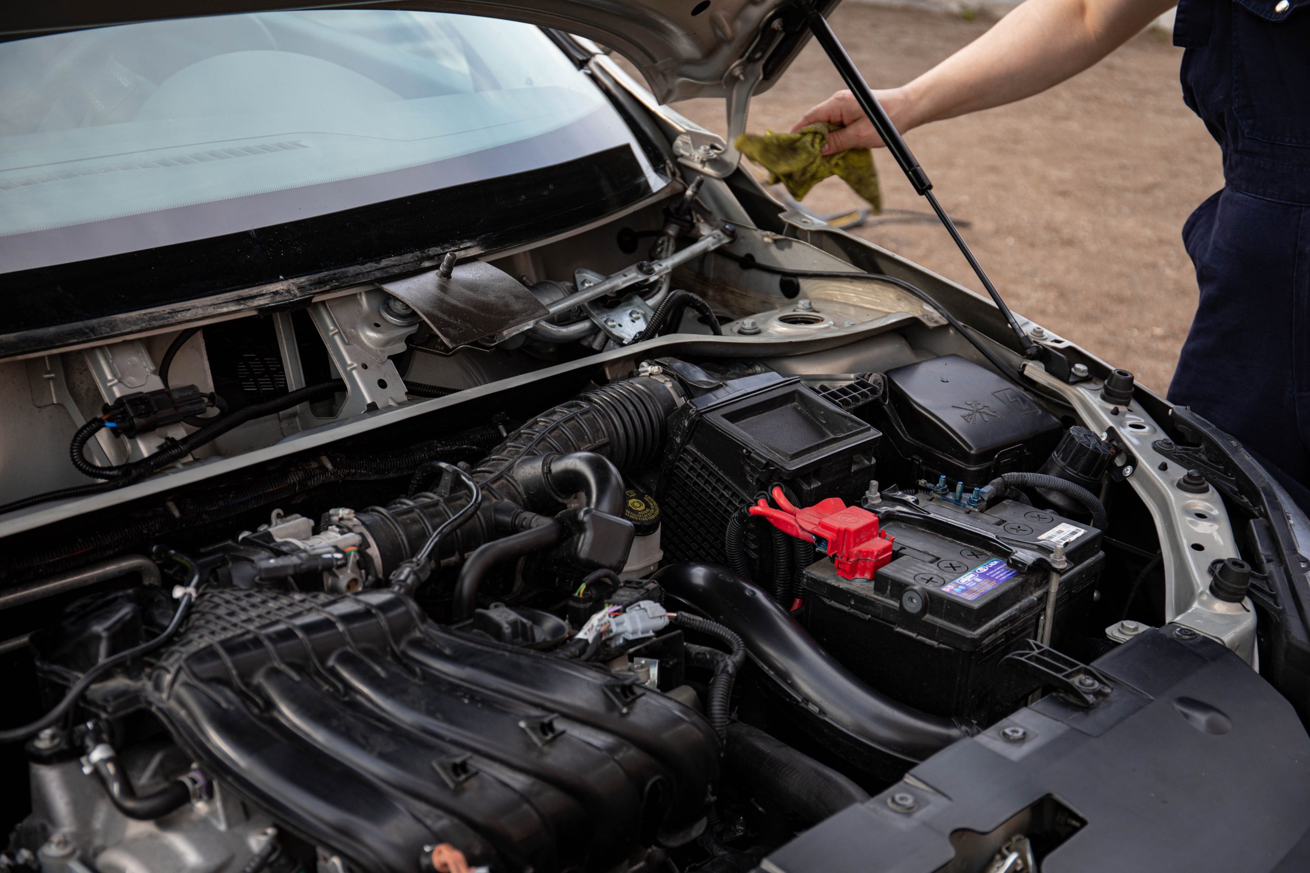 Mécanicien vérifiant moteur et batterie voiture