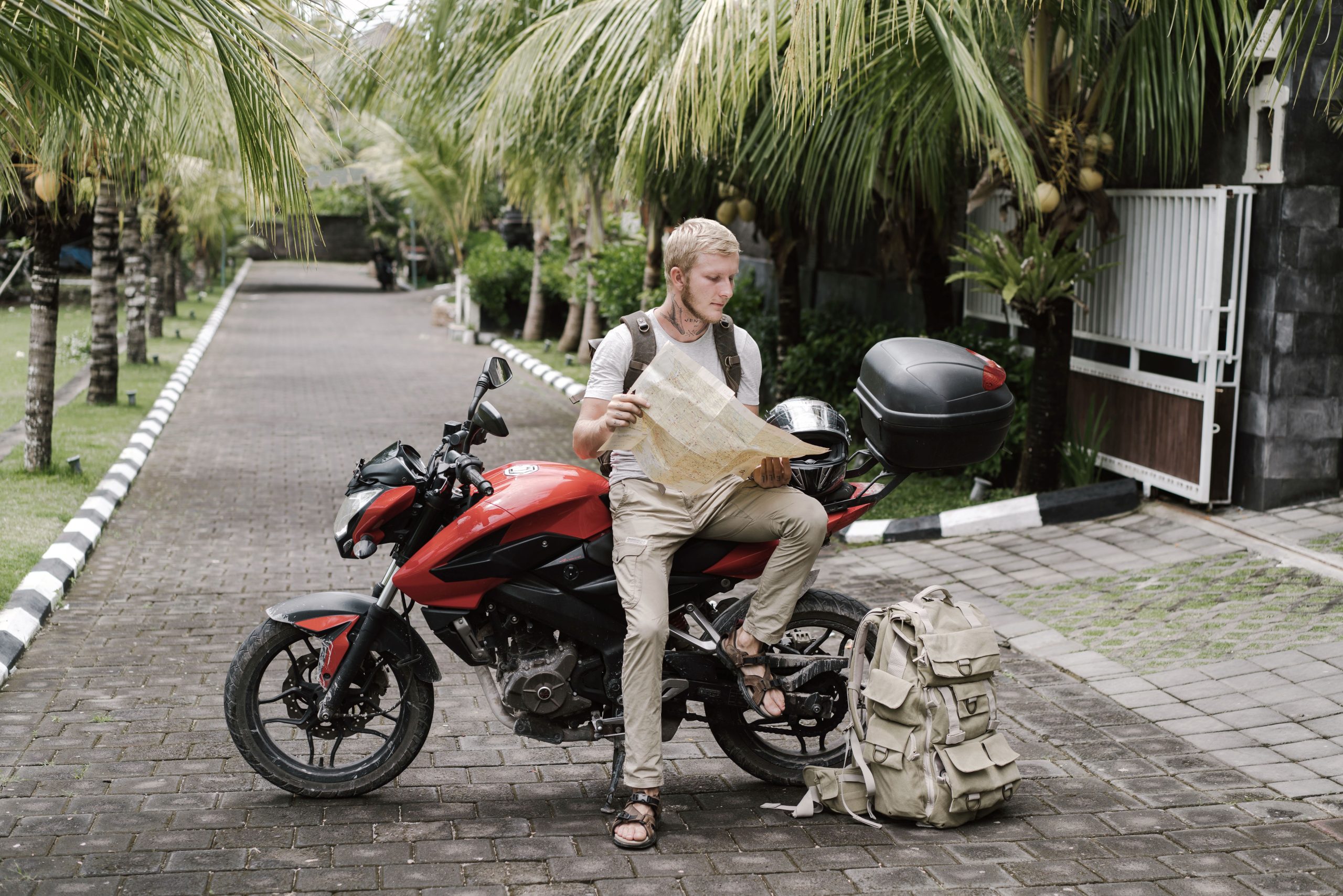 Motard touriste consulte carte près de sa moto