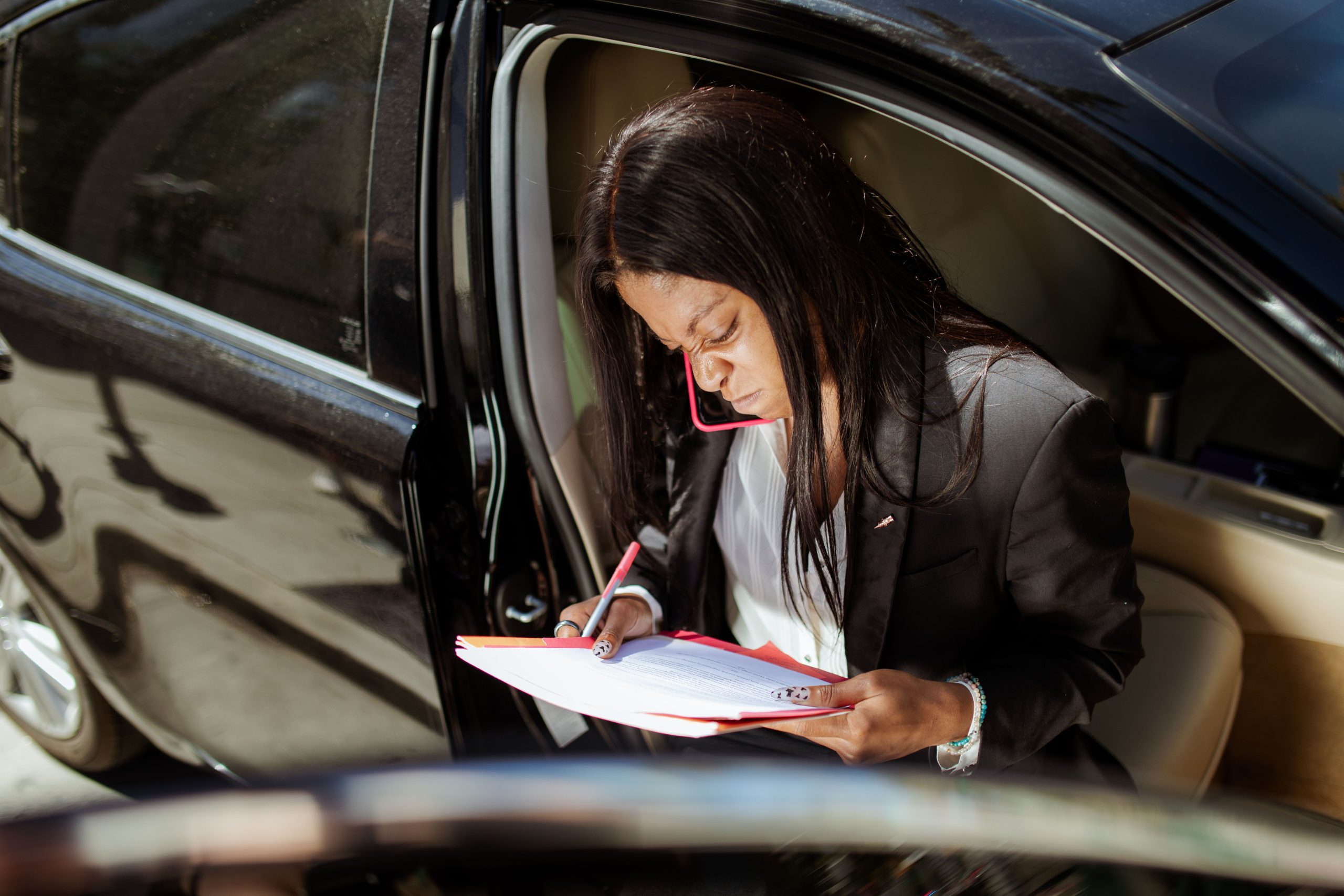 Femme d'affaires analysant des documents en voiture