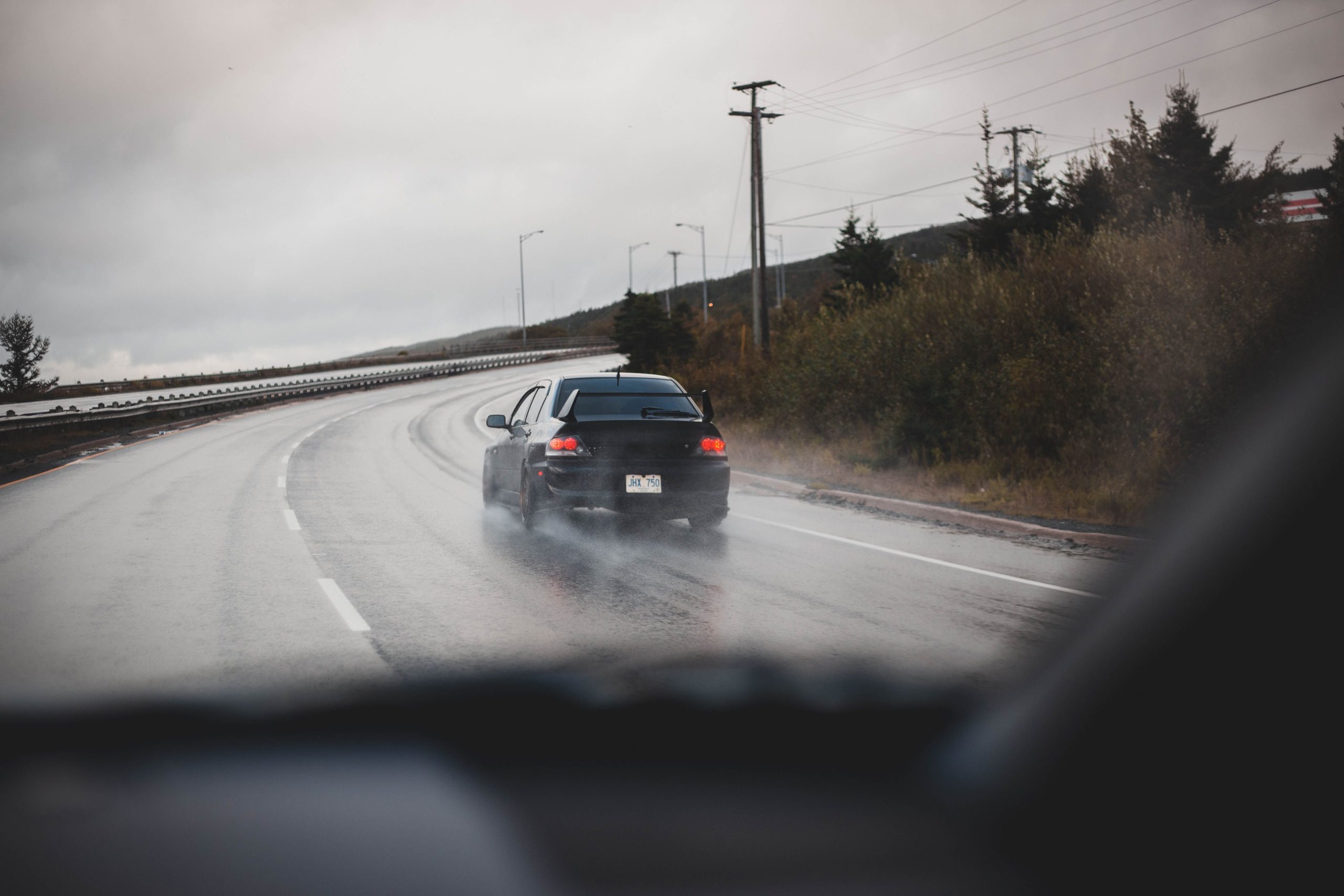 Voiture noire conduisant sous la pluie
