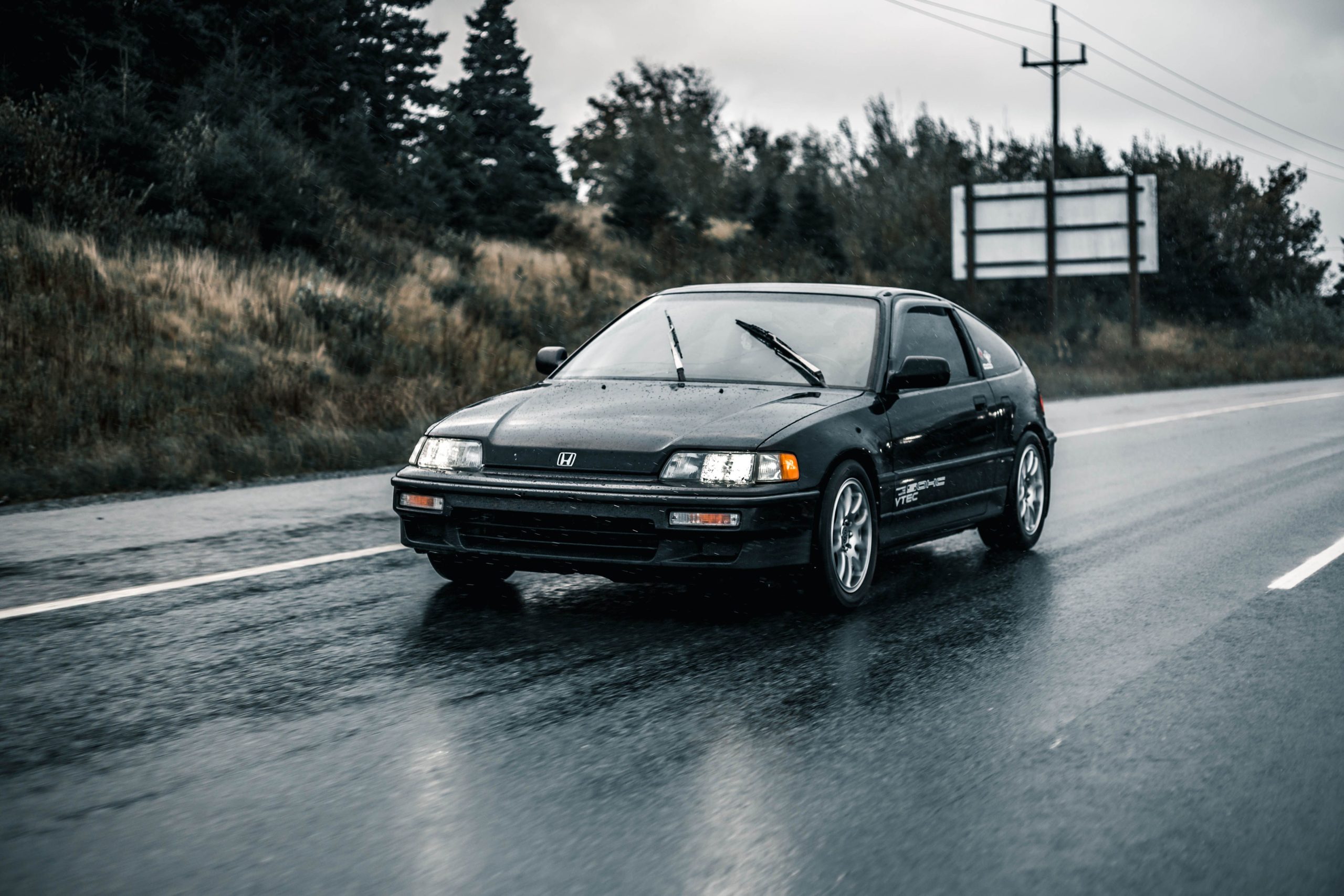 Voiture noire roulant sur route mouillée