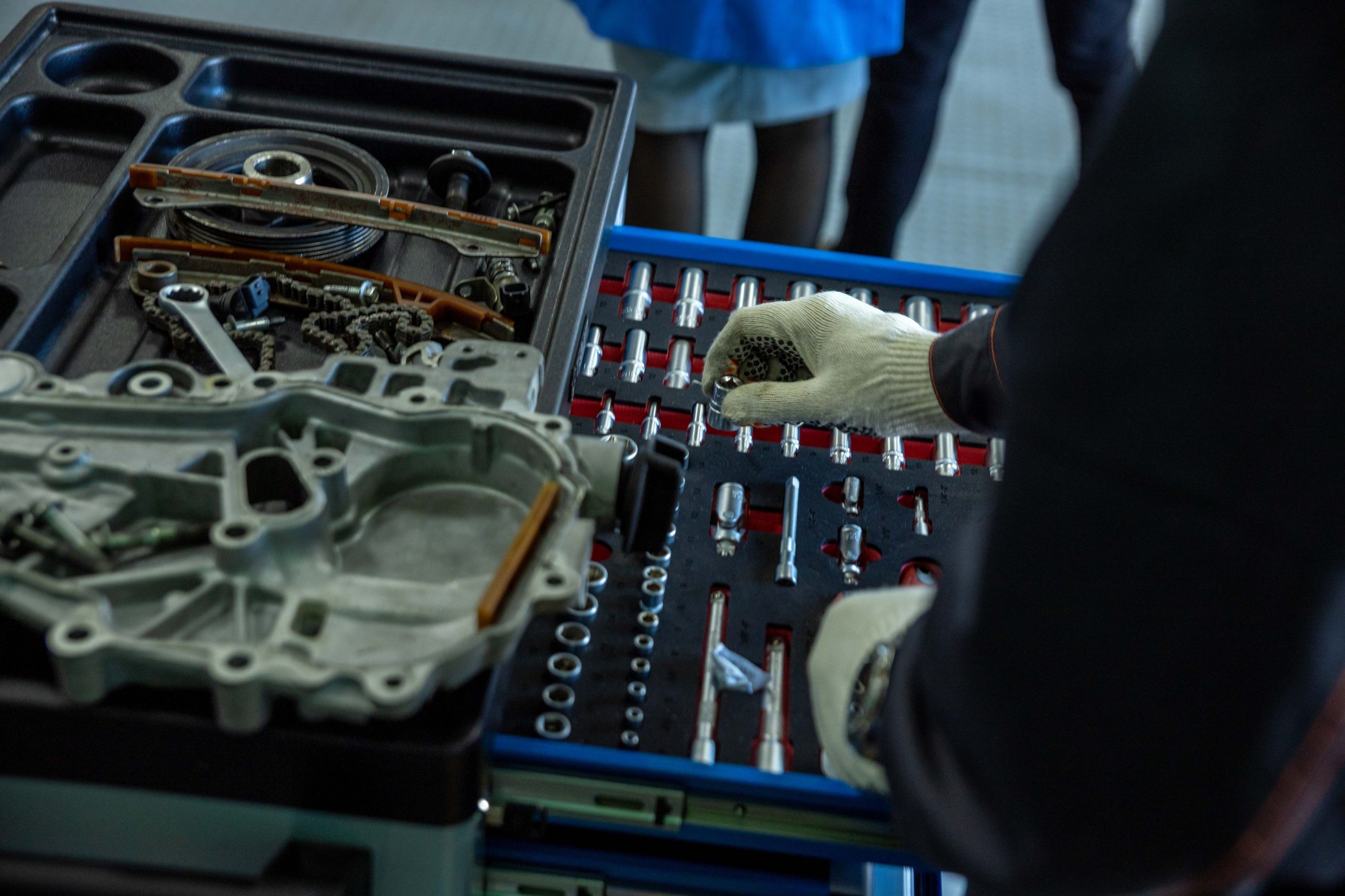 Mécanicien organisant pièces moteur et outils atelier