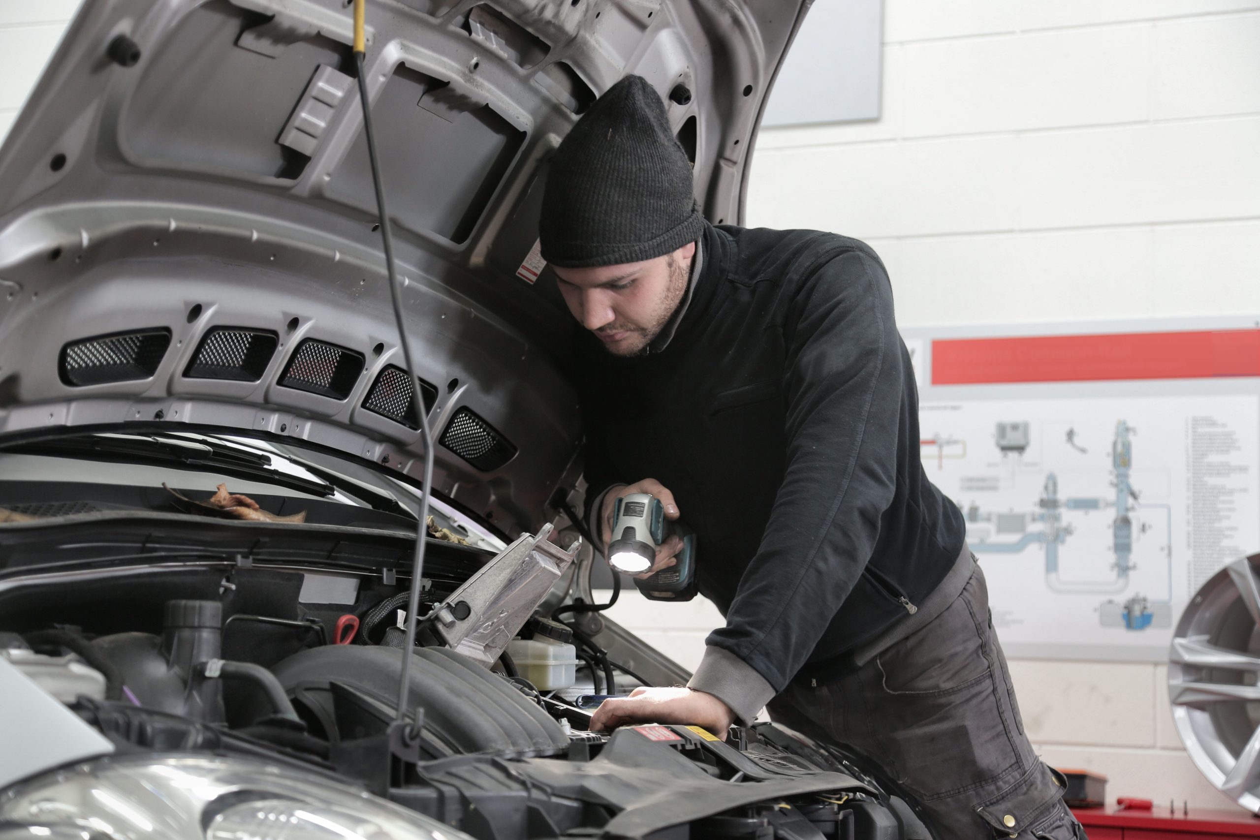 Mécanicien inspectant moteur voiture en garage