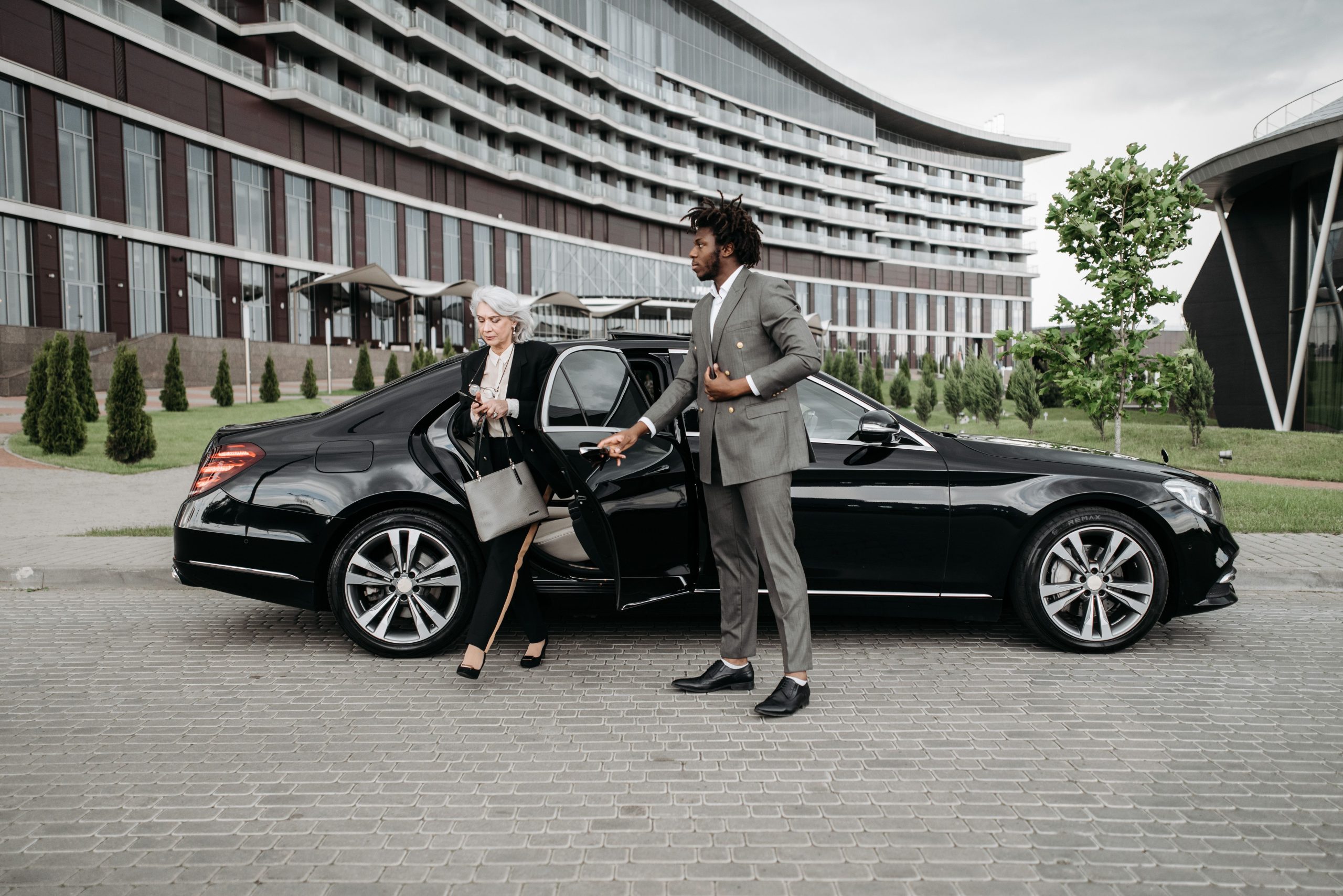 Chauffeur aide femme affaires voiture luxe