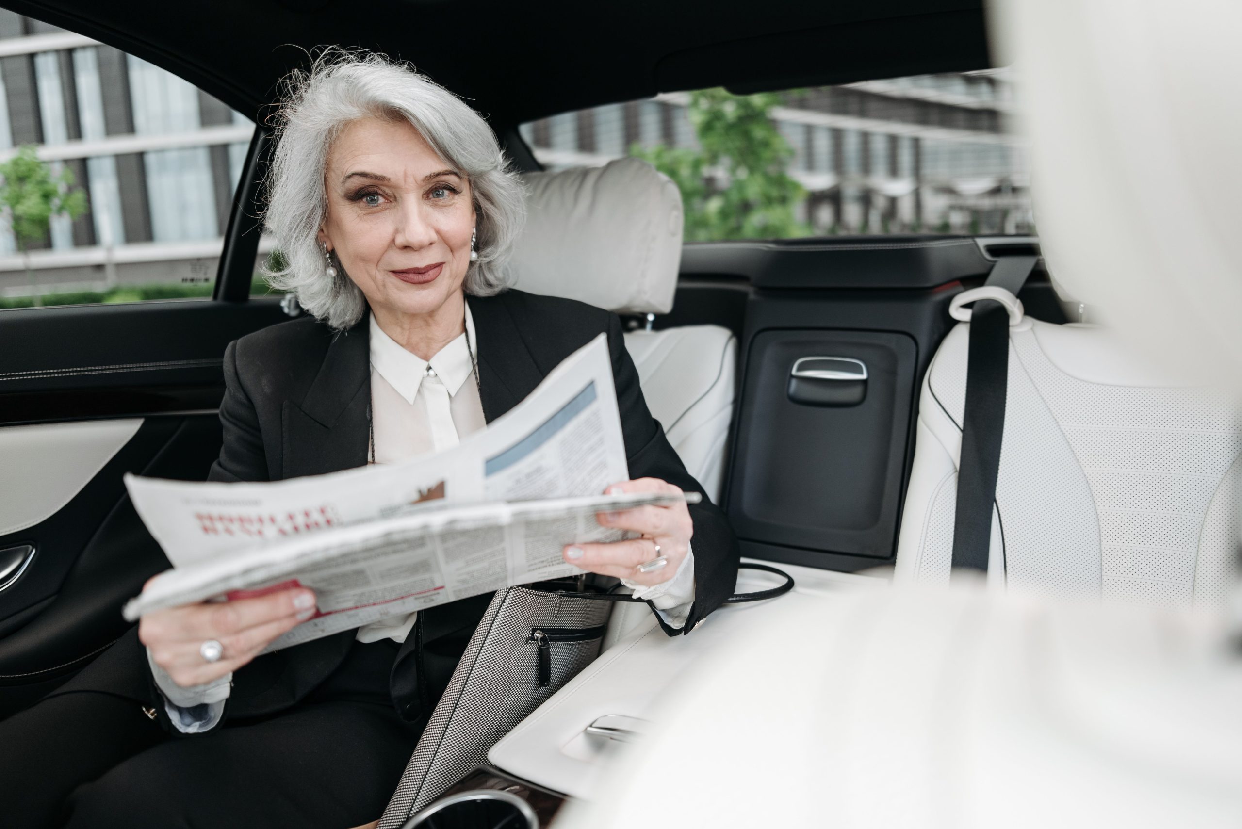 Femme lisant un journal dans sa voiture