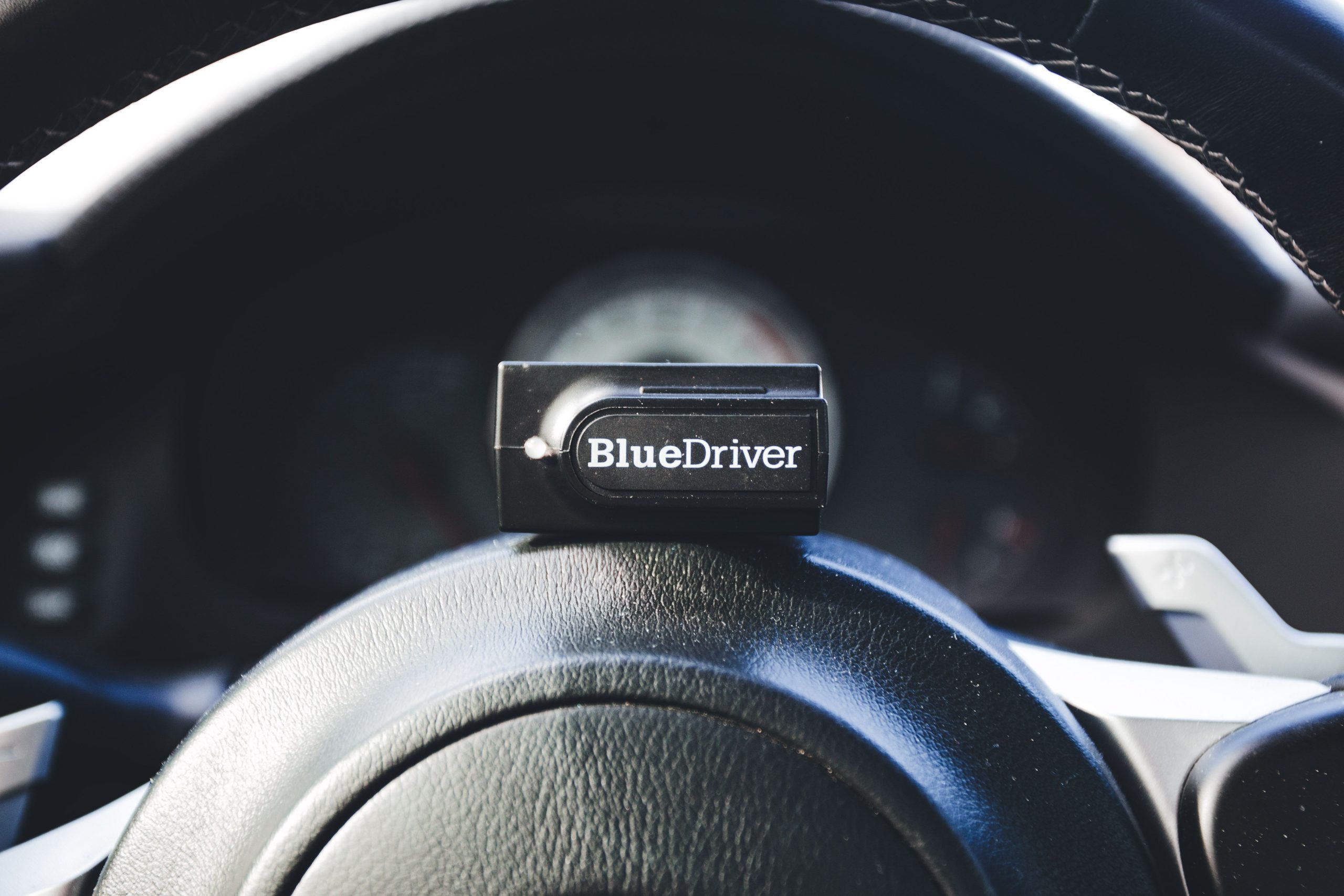 Lecteur de codes BlueDriver posé sur volant automobile