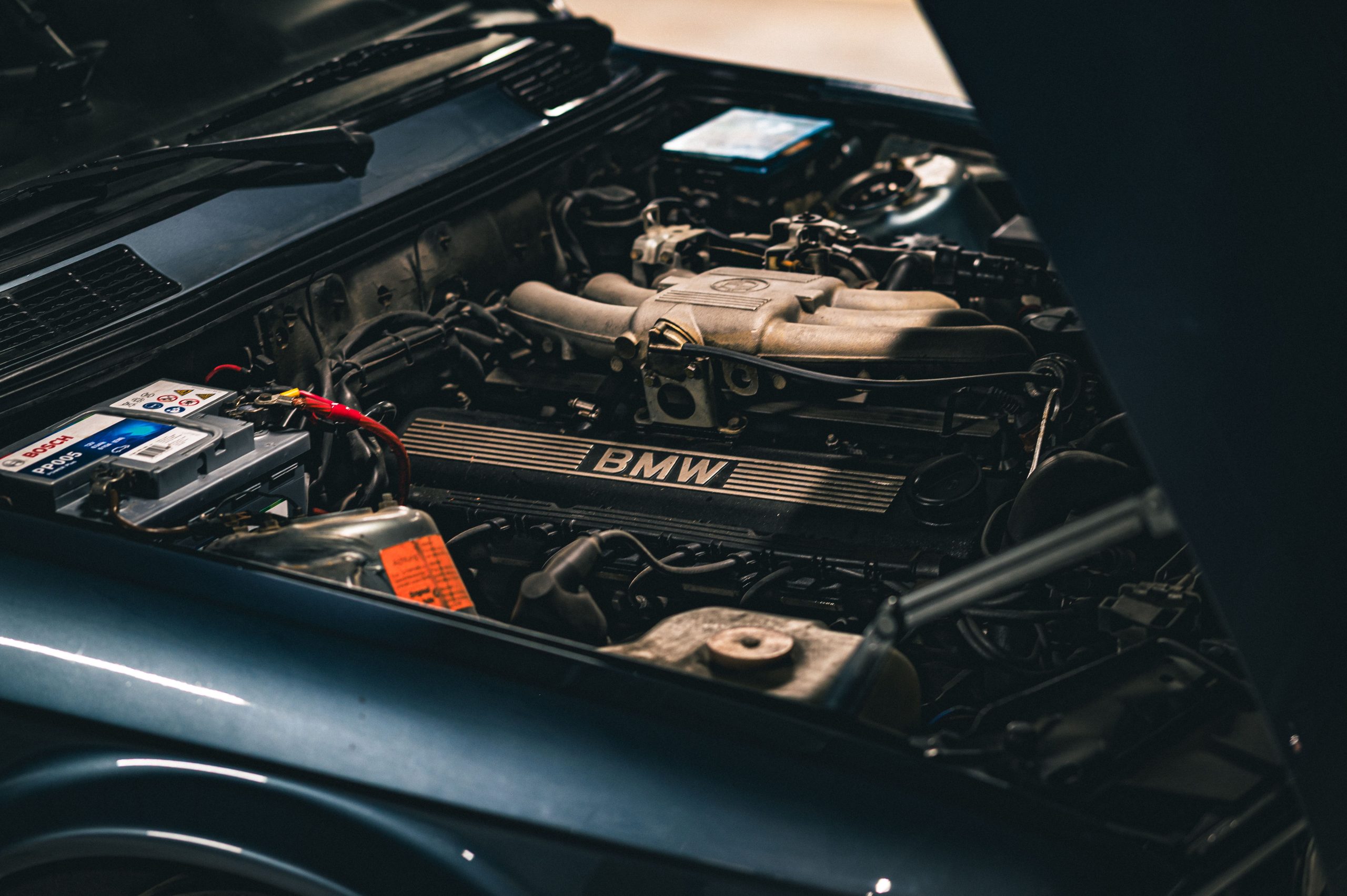 Moteur BMW avec batterie visible en garage
