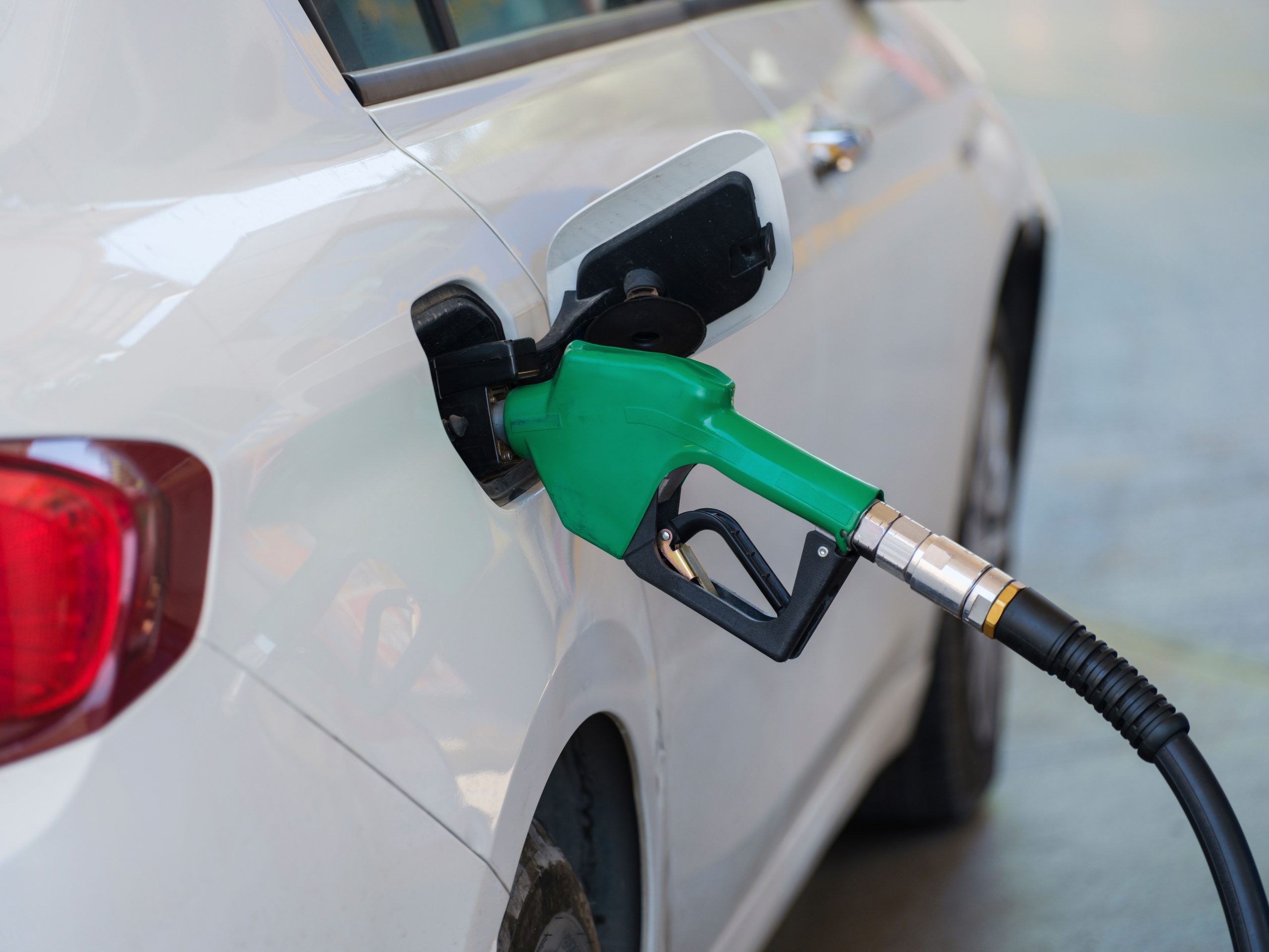 Pistolet vert ravitaillant une voiture blanche