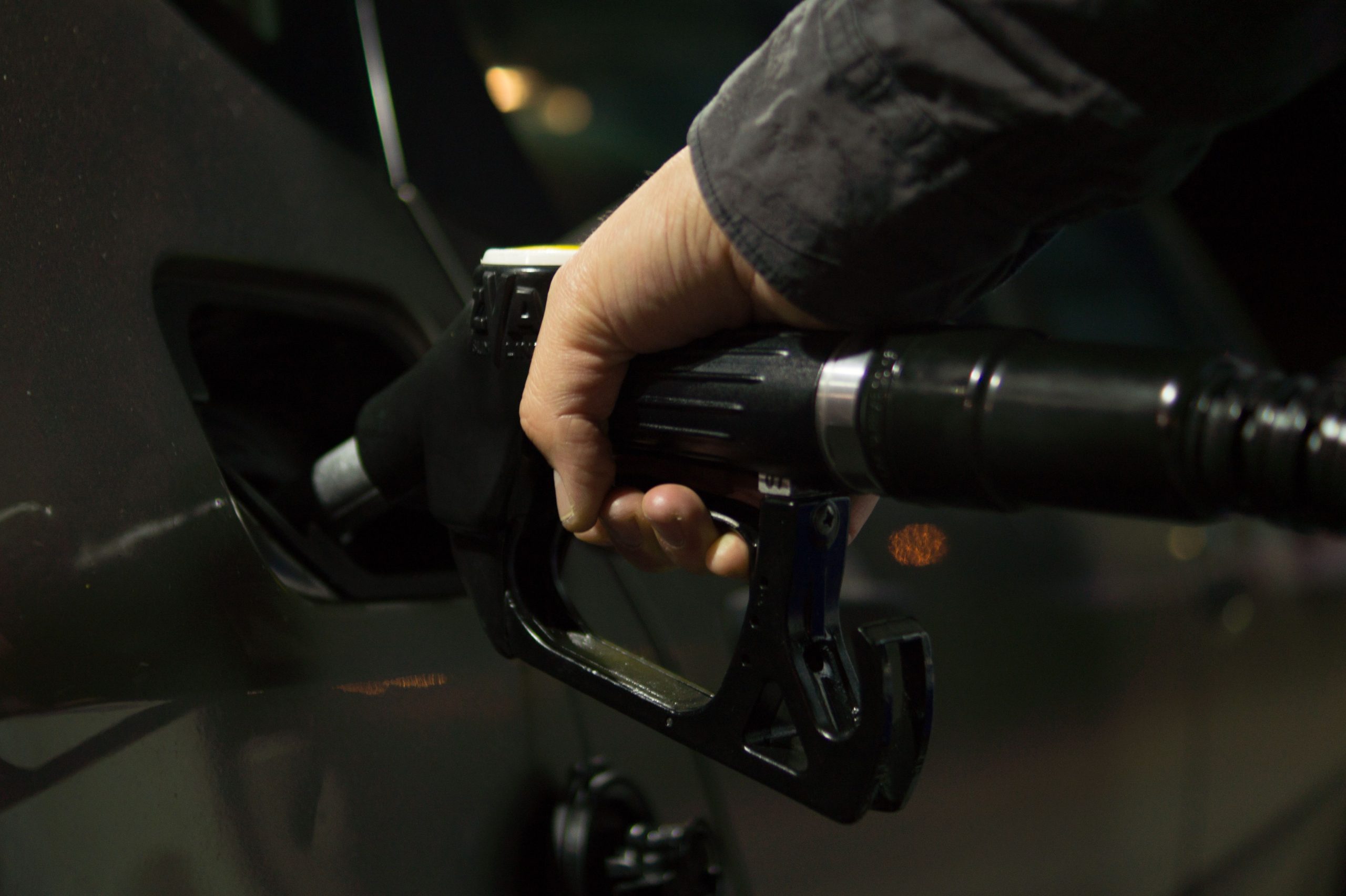 Automobiliste ravitaillant son véhicule la nuit