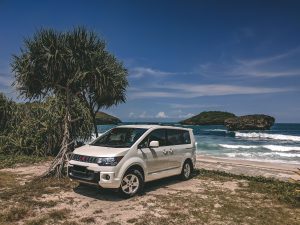 SUV blanc garé sur plage paradisiaque