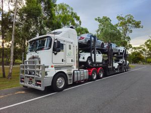 Camion porte voitures transportant des véhicules sur route