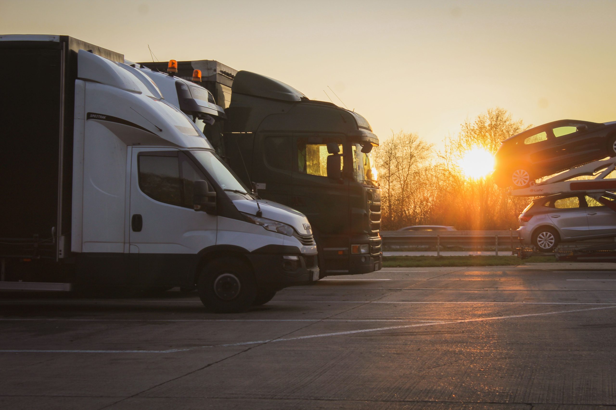 Rangée de camions porte voitures garés au coucher du soleil