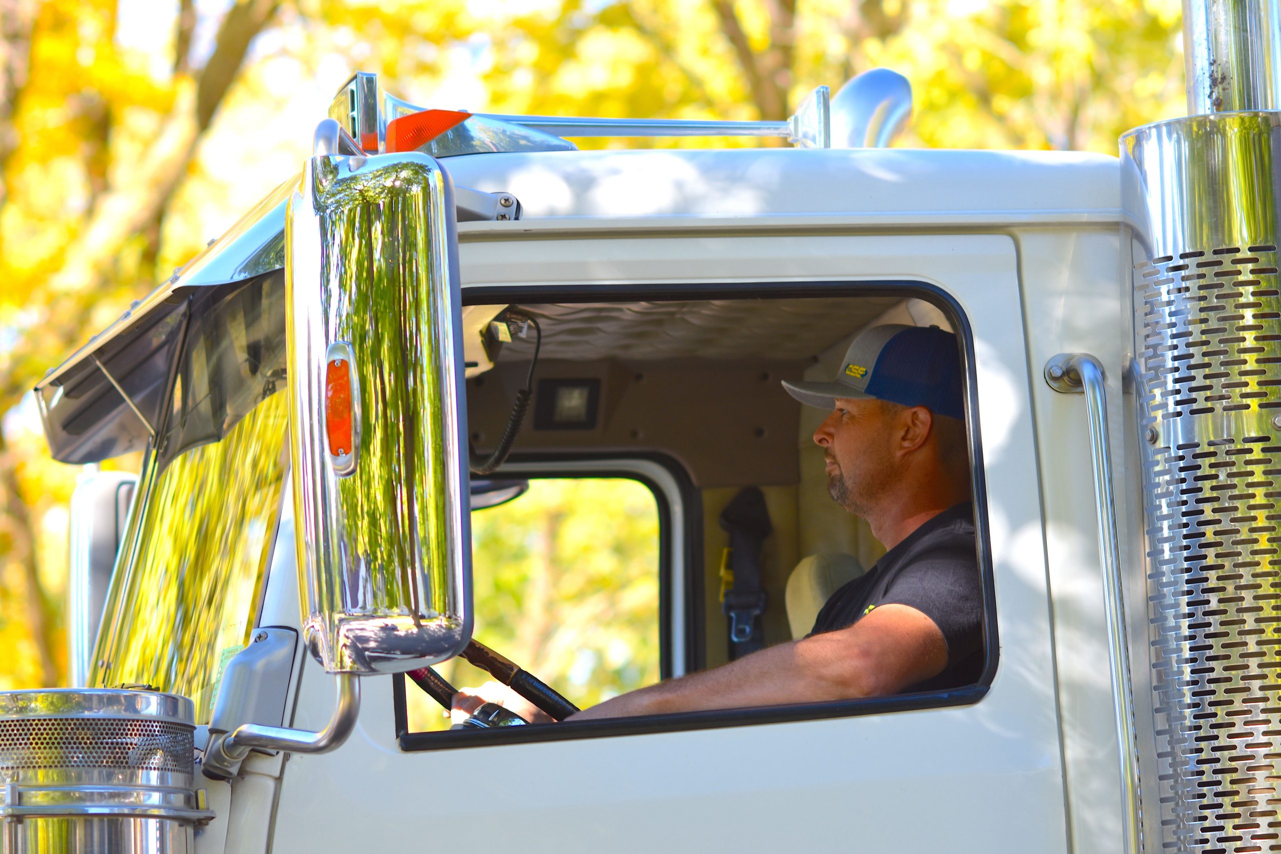 Chauffeur conduisant un poids lourd sous le soleil