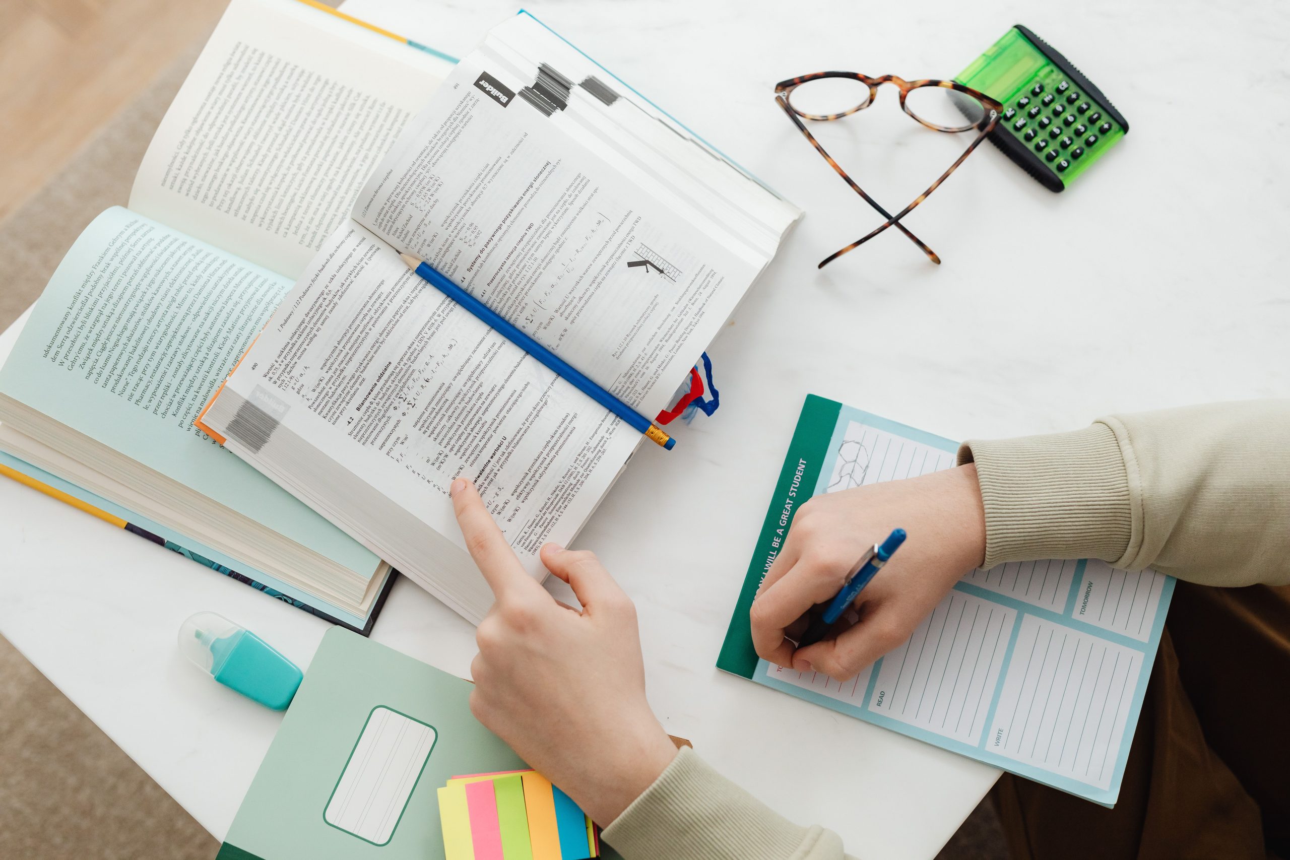 Etudiant révisant avec livres et cahier