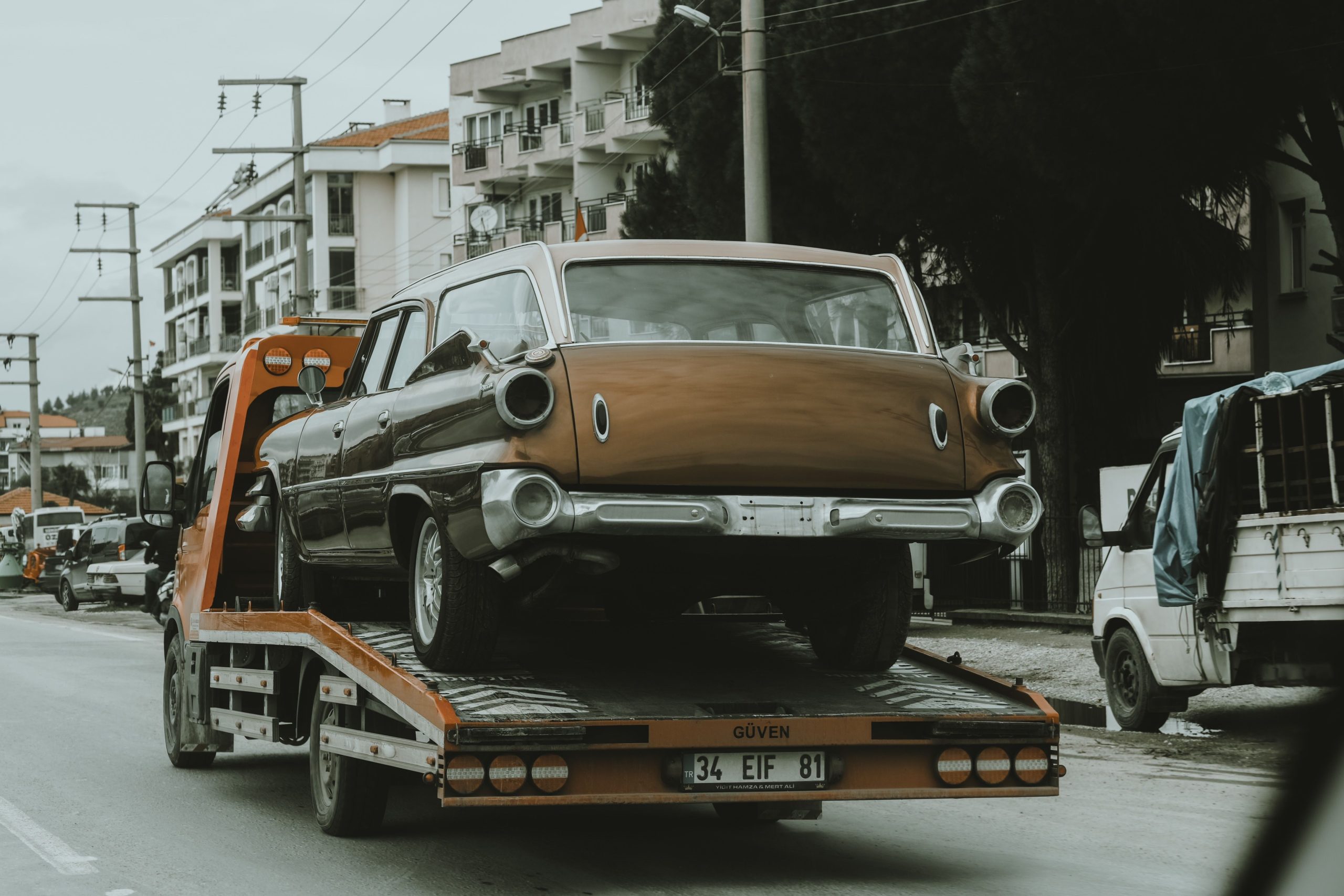 Voiture ancienne chargée sur une dépanneuse en ville